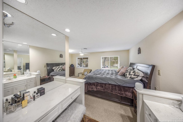 carpeted bedroom with sink and a textured ceiling