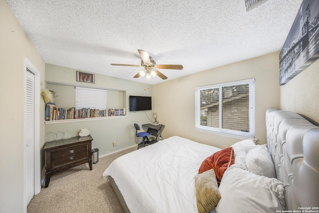 carpeted bedroom featuring ceiling fan and a textured ceiling