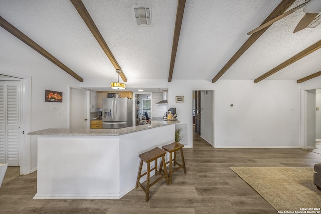 kitchen featuring stainless steel fridge with ice dispenser, wood-type flooring, kitchen peninsula, and a textured ceiling