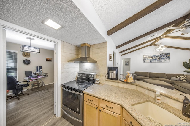 kitchen featuring wall chimney range hood, sink, hardwood / wood-style floors, a textured ceiling, and stainless steel range with electric cooktop