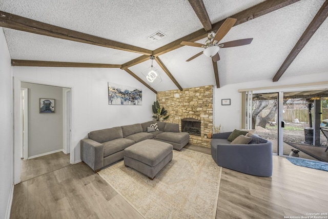 living room with hardwood / wood-style flooring, lofted ceiling with beams, and a textured ceiling