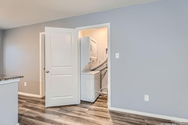 interior space with hardwood / wood-style floors and stacked washer / dryer