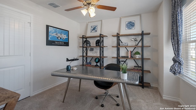 carpeted office space with ceiling fan