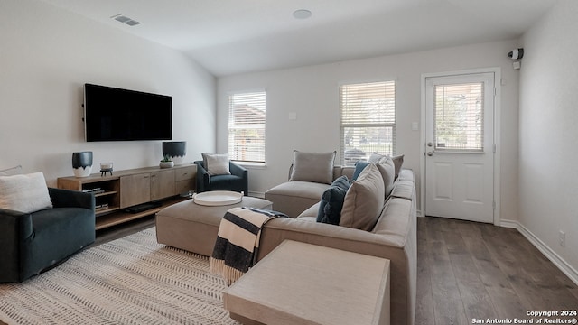 living room featuring lofted ceiling and hardwood / wood-style flooring