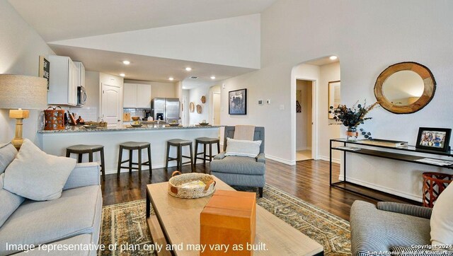 living room featuring high vaulted ceiling and dark hardwood / wood-style floors