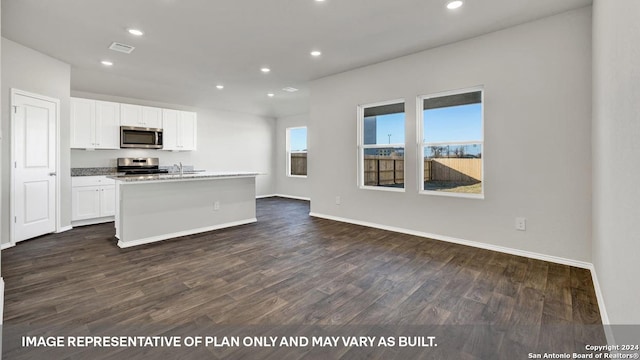 kitchen featuring sink, white cabinetry, stainless steel appliances, an island with sink, and dark hardwood / wood-style flooring