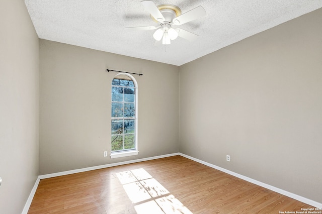 unfurnished room featuring wood-type flooring, plenty of natural light, ceiling fan, and a textured ceiling