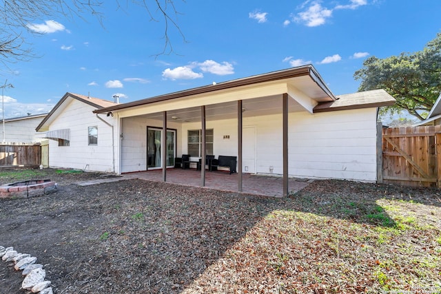 rear view of house featuring a patio area and a fire pit