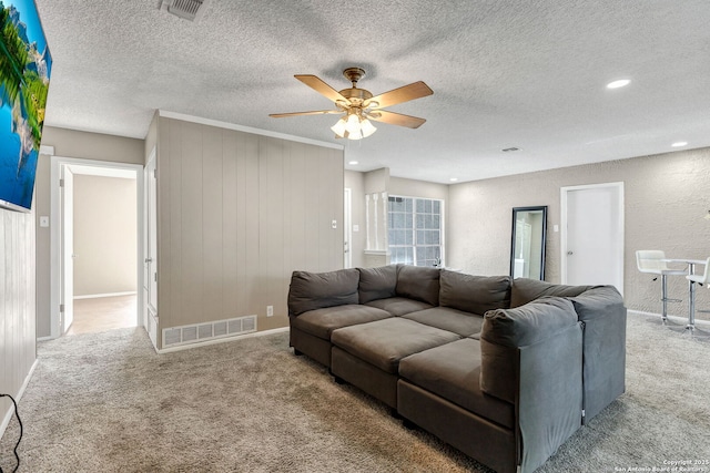 living room featuring ceiling fan, light carpet, and a textured ceiling