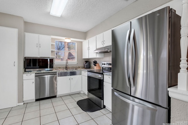 kitchen featuring white cabinetry, sink, light tile patterned floors, and appliances with stainless steel finishes