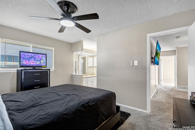 bedroom with sink, ensuite bath, light carpet, a textured ceiling, and ceiling fan