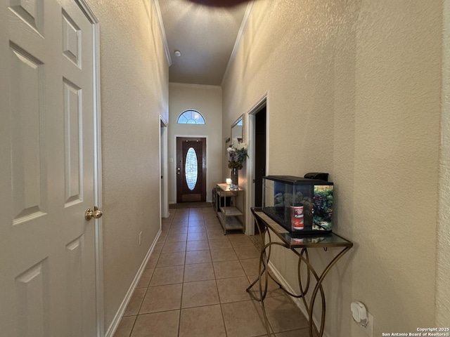 doorway to outside featuring ornamental molding and light tile patterned floors