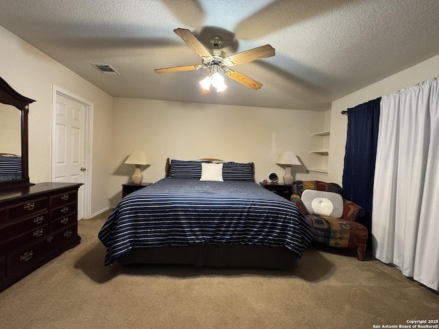 carpeted bedroom with ceiling fan and a textured ceiling