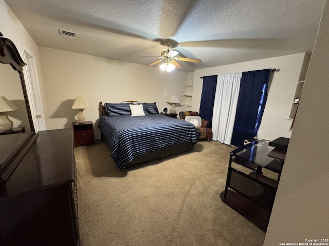 bedroom featuring ceiling fan, carpet, and a textured ceiling