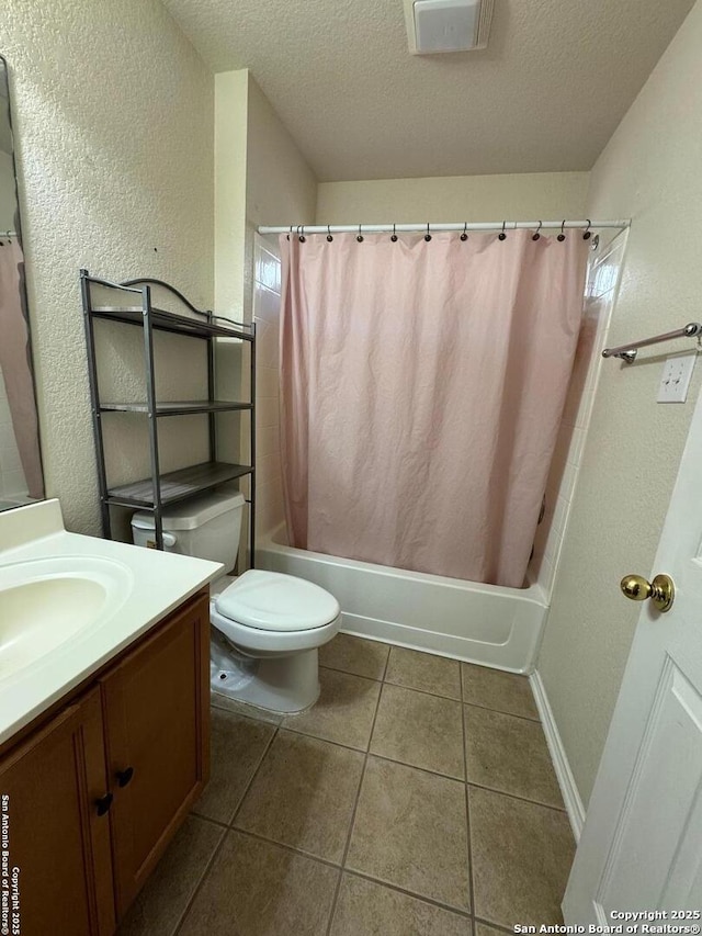 full bathroom featuring vanity, tile patterned flooring, toilet, and a textured ceiling