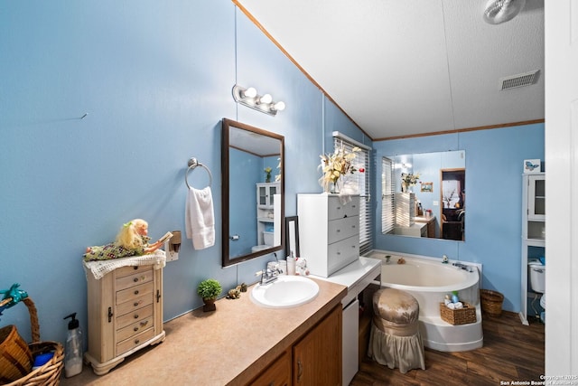 bathroom featuring hardwood / wood-style floors, vanity, a washtub, toilet, and crown molding