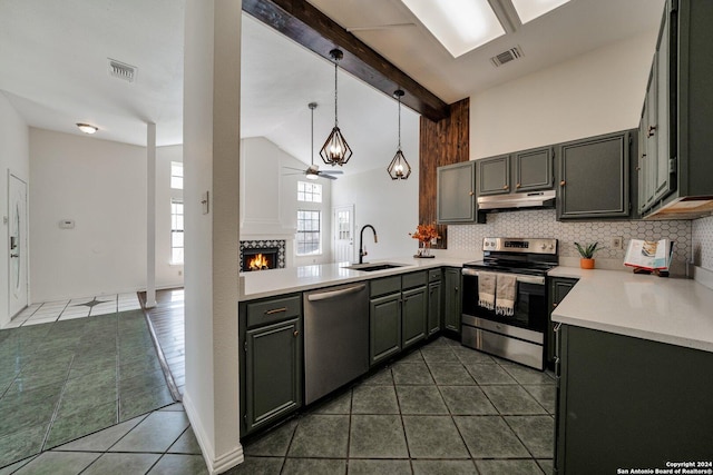 kitchen featuring pendant lighting, dark tile patterned flooring, decorative backsplash, and stainless steel appliances