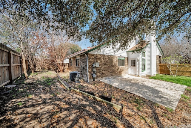 rear view of property with cooling unit and a patio