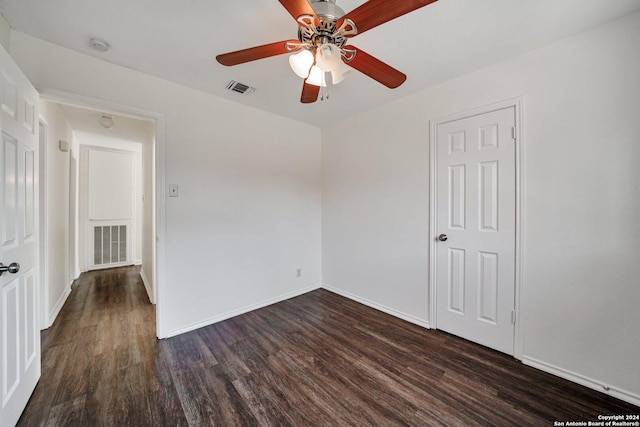 empty room with dark wood-type flooring and ceiling fan