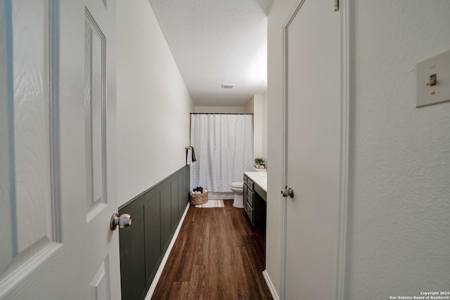 bathroom with hardwood / wood-style flooring, vanity, a textured ceiling, and toilet