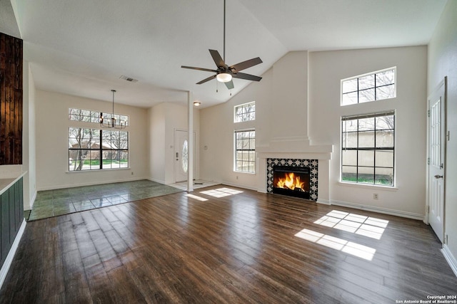 unfurnished living room featuring dark hardwood / wood-style flooring, plenty of natural light, and a tile fireplace