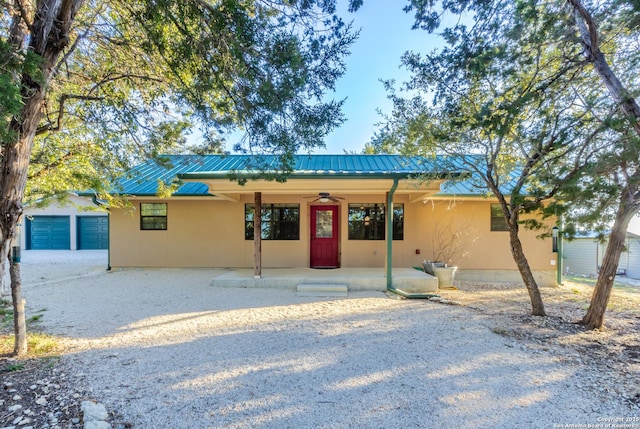 view of front facade with a garage, an outdoor structure, and ceiling fan