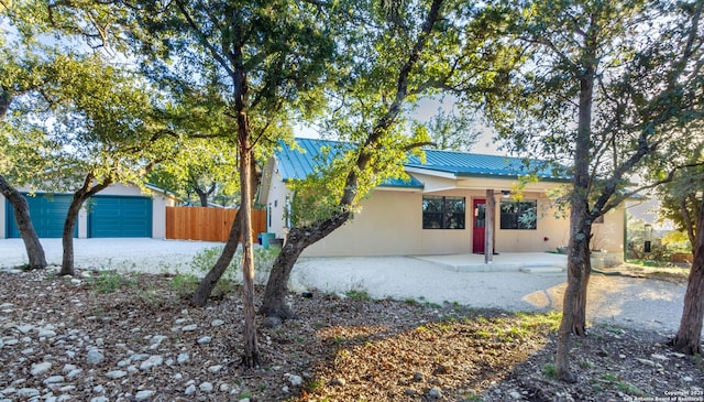 single story home with a garage, a patio, and an outbuilding