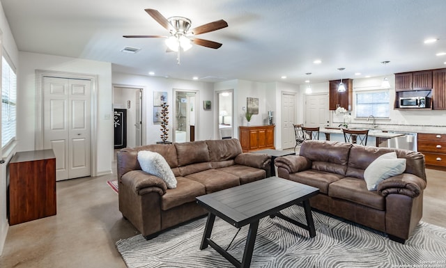 living room featuring sink and ceiling fan