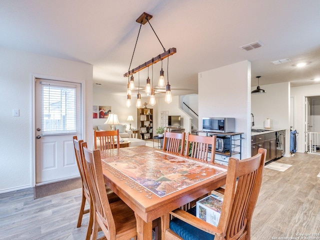 dining area featuring beverage cooler and light hardwood / wood-style floors