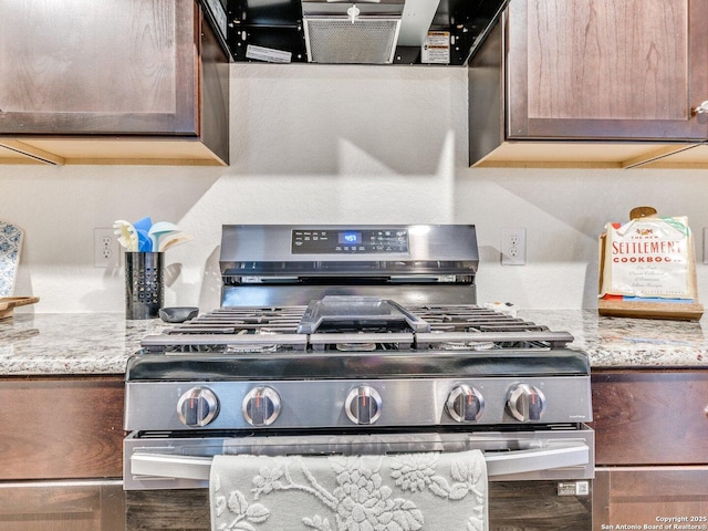 interior space featuring extractor fan, stainless steel gas range, and light stone counters