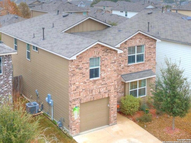 view of front of property with a garage and central air condition unit