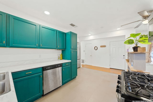 kitchen with sink, stainless steel appliances, ceiling fan, and green cabinets