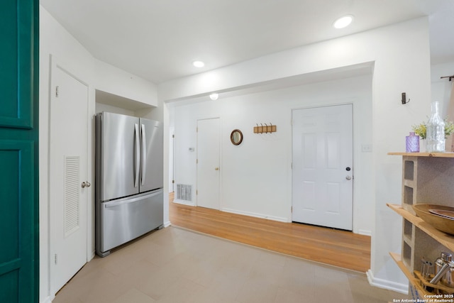 kitchen with light hardwood / wood-style flooring and stainless steel refrigerator