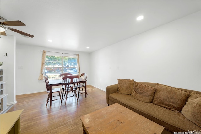 living room with light hardwood / wood-style flooring and ceiling fan