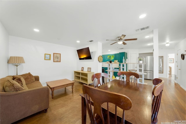 dining space with light hardwood / wood-style floors and ceiling fan