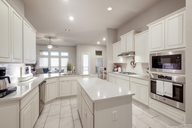 kitchen featuring white cabinetry, stainless steel appliances, kitchen peninsula, and a kitchen island