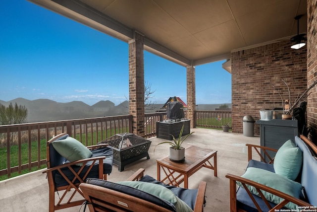 view of patio featuring a mountain view and a fire pit