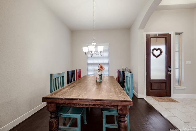 dining space featuring hardwood / wood-style flooring and an inviting chandelier