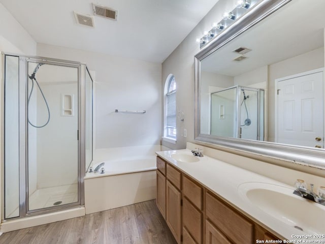 bathroom featuring vanity, hardwood / wood-style flooring, and shower with separate bathtub