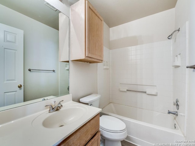 full bathroom with vanity, tiled shower / bath combo, and toilet