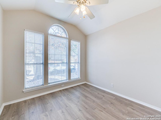 unfurnished room with ceiling fan, vaulted ceiling, and light hardwood / wood-style flooring