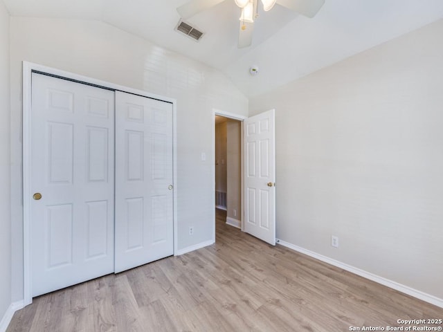 unfurnished bedroom featuring ceiling fan, lofted ceiling, a closet, and light wood-type flooring