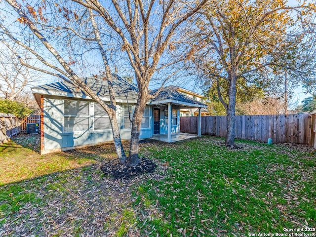 view of front of home featuring a patio area, a front yard, and central air condition unit