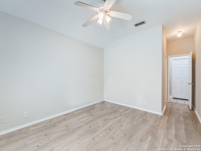 spare room featuring light hardwood / wood-style flooring, ceiling fan, and vaulted ceiling