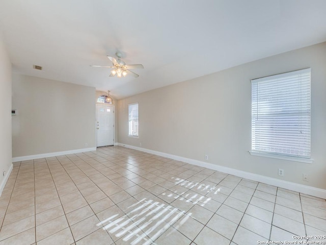 tiled spare room with ceiling fan