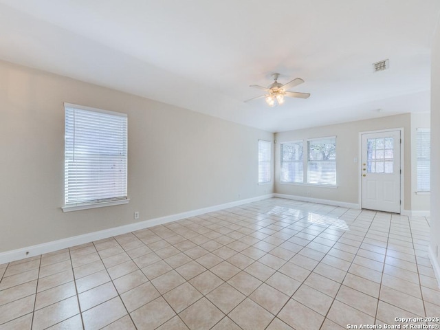 tiled spare room with ceiling fan