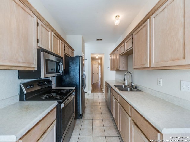 kitchen featuring sink, light tile patterned floors, light brown cabinets, and appliances with stainless steel finishes