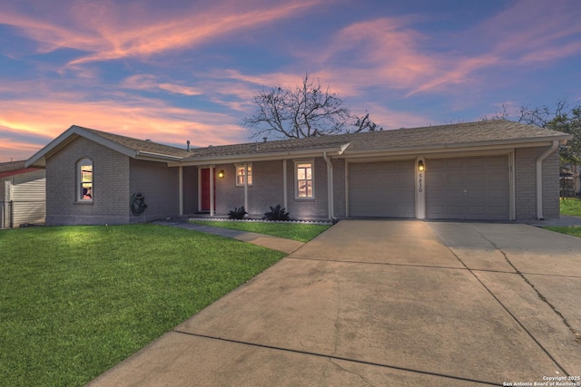 ranch-style house with a garage and a yard