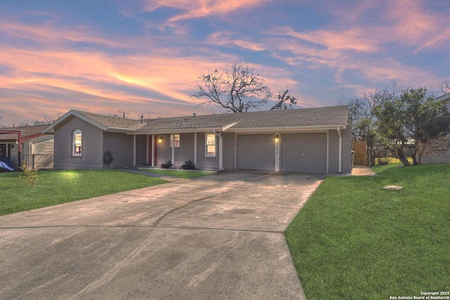 ranch-style home with a garage and a yard