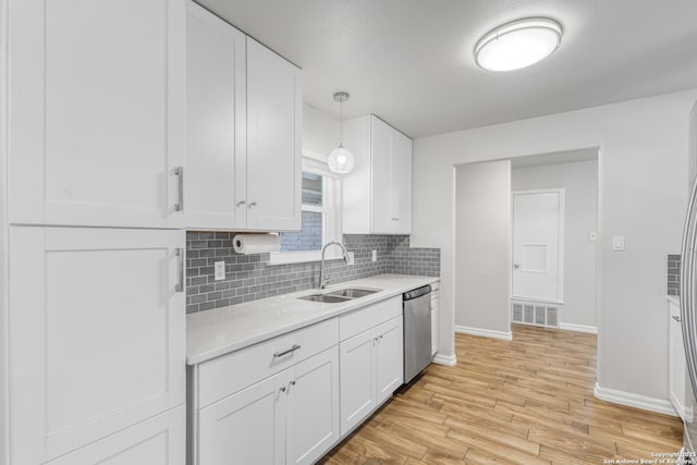 kitchen featuring sink, stainless steel dishwasher, hanging light fixtures, and white cabinets